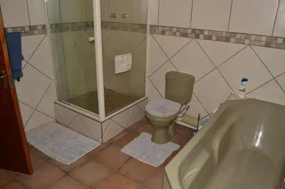 a bathroom with a shower and a toilet and a tub at Guesthouse in the Waterberg in Ouklip