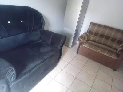 a living room with a leather couch and a chair at Simekhona Guest House in Aangewysd