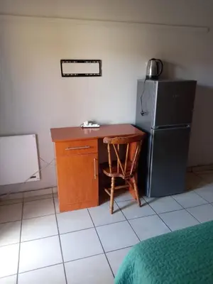 a kitchen with a desk and a refrigerator at Simekhona Guest House in Aangewysd