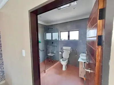 a bathroom with a toilet and a shower and a sink at Hlako Lodge in Ga-Tisana
