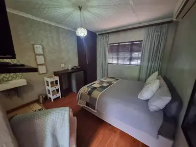 a bedroom with a large bed and a window at Honeyball Guest rooms in Mokopane