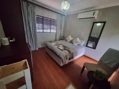 a bedroom with a bed and a chair and a window at Honeyball Guest rooms in Mokopane