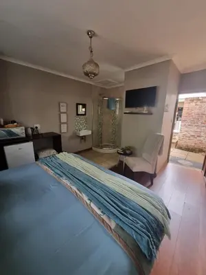 a bedroom with a bed with a blue blanket on it at Honeyball Guest rooms in Mokopane