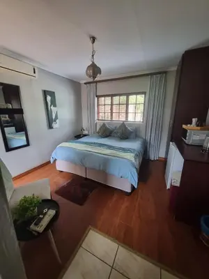 a bedroom with a bed and a large window at Honeyball Guest rooms in Mokopane