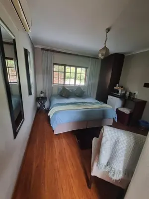 a bedroom with a bed and a wooden floor at Honeyball Guest rooms in Mokopane