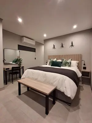 a bedroom with a bed and a desk and a table at King size bed-NO loadshedding-Free Wi-Fi in Pretoria