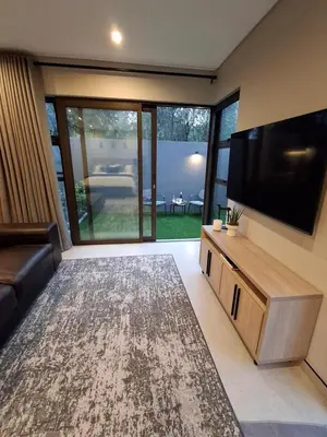 a living room with a flat screen tv and a couch at King size bed-NO loadshedding-Free Wi-Fi in Pretoria