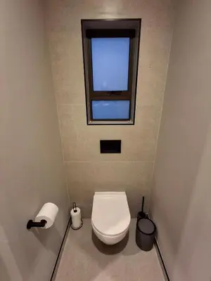 a small bathroom with a toilet and a window at King size bed-NO loadshedding-Free Wi-Fi in Pretoria