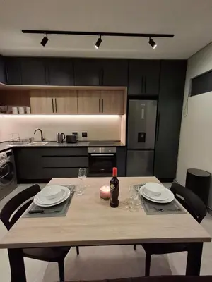 a wooden table with plates and wine bottles on it in a kitchen at King size bed-NO loadshedding-Free Wi-Fi in Pretoria