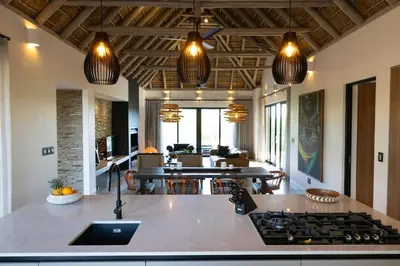 a kitchen and living room with a stove top at Villa Visvanger - Villa with river deck nearby Kruger in Hoedspruit