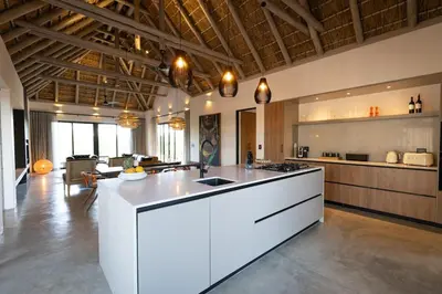 a large kitchen with a white island in a room at Villa Visvanger - Villa with river deck nearby Kruger in Hoedspruit