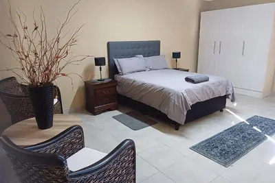 a bedroom with a bed and a table and chairs at Corea Game Ranch in Alldays