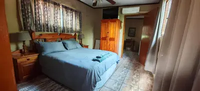 a bedroom with a bed with a wooden head board at Corea Game Ranch in Alldays
