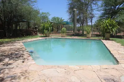 a swimming pool in a yard with a fence at Corea Game Ranch in Alldays