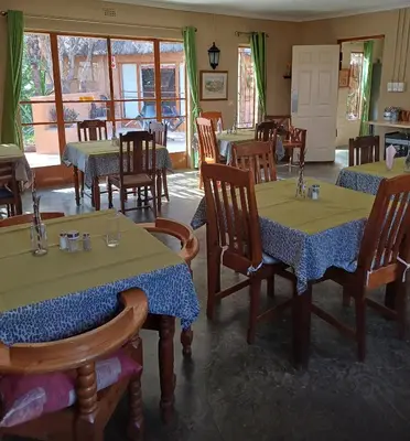 a restaurant with tables and chairs in a room at Corea Game Ranch in Alldays