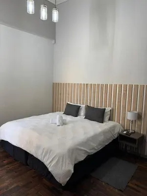 a bedroom with a large bed with a wooden headboard at Kioma Guest House in Mokopane