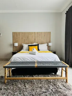 a bedroom with a large bed with a wooden headboard at Kioma Guest House in Mokopane