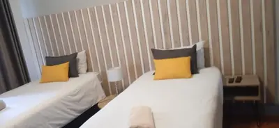 a room with two beds with yellow pillows at Kioma Guest House in Mokopane