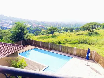a person standing next to a swimming pool at Elephant Villa Private Room in Nelspruit