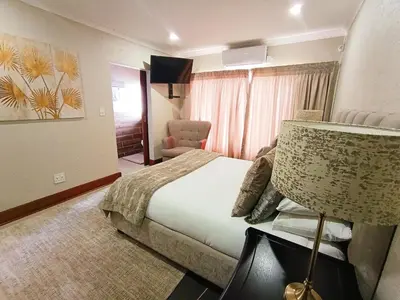 a hotel room with a bed and a chair at Elephant Villa Private Room in Nelspruit
