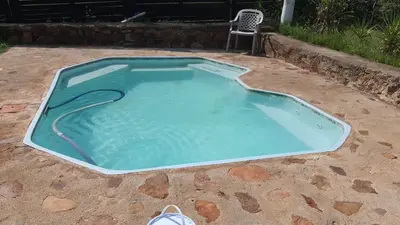 a small swimming pool in a yard with a chair at Chalet 2 Camping Style at Cynthias Country Outside bathrooms in Hartbeespoort