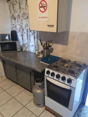 a kitchen with a stove and a counter top at Chalet 2 Camping Style at Cynthias Country Outside bathrooms in Hartbeespoort