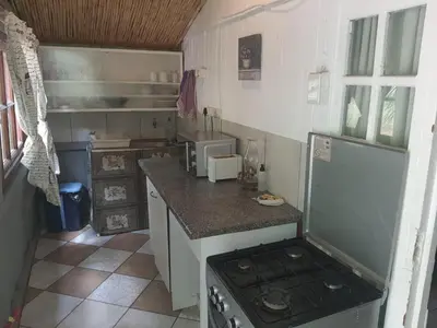 a small kitchen with a stove and a counter top at Chalet 3 at Cynthias Country in Hartbeespoort