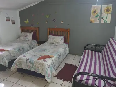 a bedroom with two beds and a bench in it at Chalet 3 at Cynthias Country in Hartbeespoort