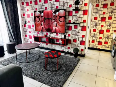 a room with a table and two chairs and a wall at Ruby Nest Modern Smart Living in Midrand