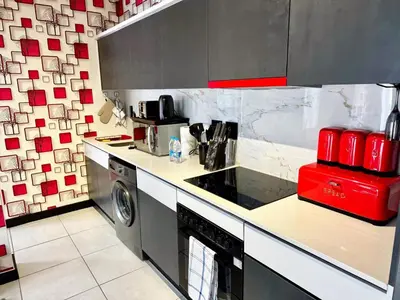 a kitchen with a stove and a washing machine at Ruby Nest Modern Smart Living in Midrand