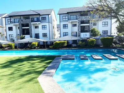 a large swimming pool in front of a building at Ruby Nest Modern Smart Living in Midrand
