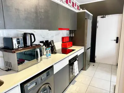 a kitchen with a washer and a washing machine at Ruby Nest Modern Smart Living in Midrand