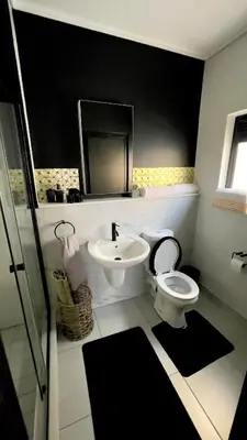 a bathroom with a white toilet and a sink at Xiluva Flower Smart Apartment in Midrand