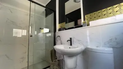 a bathroom with a toilet and a sink and a shower at Xiluva Flower Smart Apartment in Midrand