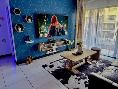 a living room with a tv on a blue wall at Xiluva Flower Smart Apartment in Midrand