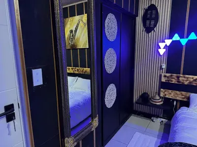 a bedroom with a mirror and a bed in it at Xiluva Flower Smart Apartment in Midrand