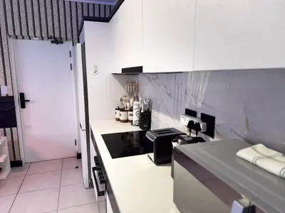 a kitchen with white cabinets and a counter top at Xiluva Flower Smart Apartment in Midrand