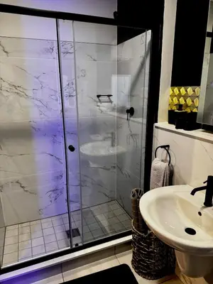 a bathroom with a shower and a sink at Xiluva Flower Smart Apartment in Midrand