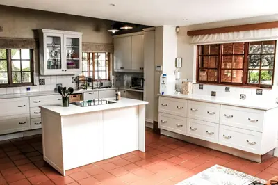 a kitchen with white cabinets and white counter tops at Ukhanya resort in Midrand