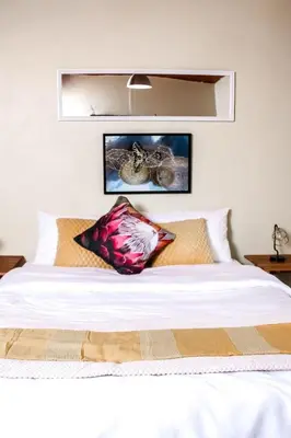 a white bed with two pillows on top of it at Ukhanya resort in Midrand