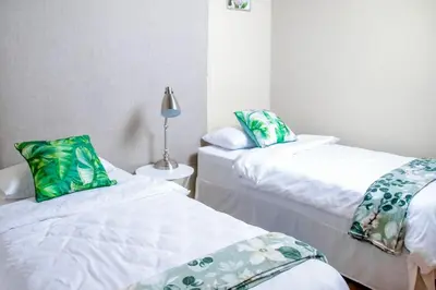 a room with two beds with green and white pillows at Ukhanya resort in Midrand