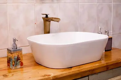 a white bath tub on a wooden counter in a bathroom at Ukhanya resort in Midrand
