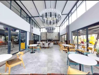 a restaurant with tables and chairs and a chandelier at Smart Home Oasis & Luxury Living in Midrand