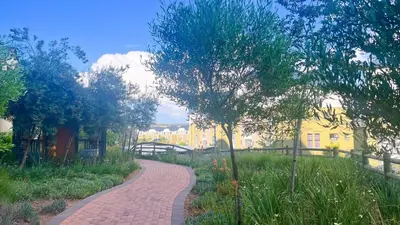 a brick path in a park with trees and buildings at Smart Home Oasis & Luxury Living in Midrand