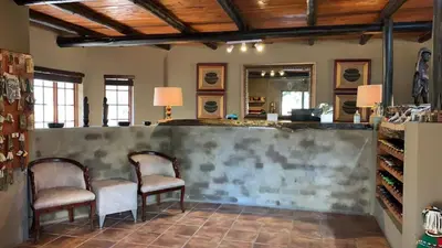 a wine tasting room with two chairs and a counter at Honeyguide Ranger Camp in Golders Green