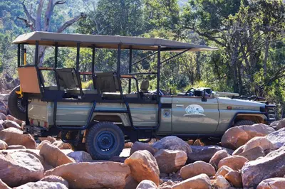 a jeep parked on a pile of rocks at Honeyguide Ranger Camp in Golders Green