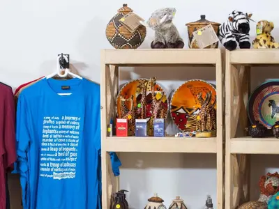 a shelf filled with lots of stuffed animals and a tshirt at Honeyguide Ranger Camp in Golders Green