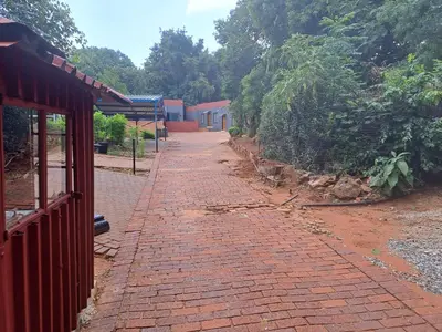 a brick walkway next to a red brick building at Better Life Guesthouse Colbyn in Pretoria