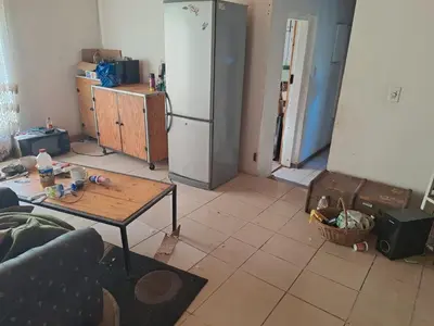 a living room with a refrigerator and a table at Better Life Guesthouse Colbyn in Pretoria
