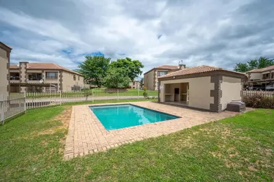 a swimming pool in the yard of a house at Self checkin - Modern 2 Bedroom Retreat - 103 in Nelspruit